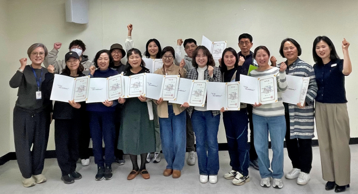 호매실장애인종합복지관 '시민옹호인 양성 교육 및 위촉식'에서 참여자들이 위촉증을 들고 기념촬영을 하고 있다.