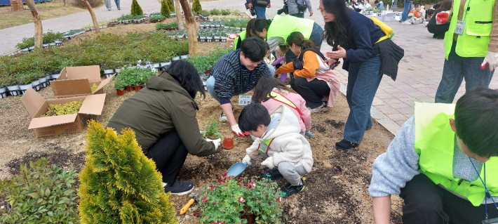 어린이집 소속 어린이들이 화초를 심고 있다.