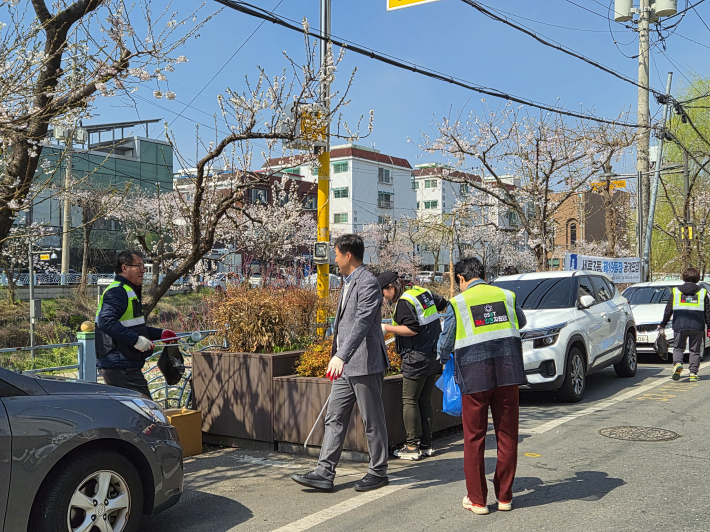 국제표준안전재단 수원영통지회 관계자들이 세류3동 행정복지센터에 돼지갈비 45인분을 전달하고, 세류3동 관계자들과 환경정화활동에 참여하고 있다.