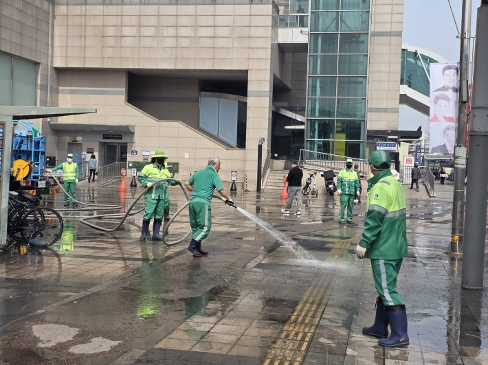 수원시 팔달구 관계자들이 수원역 광장에서 물청소하며 새봄맞이 환경정비를 하고 있다.  