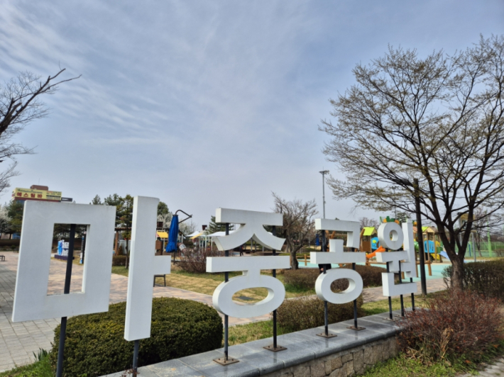 공원 놀이터에는 아이들이 뛰어놀고, 운동하는 어르신들이 보인다