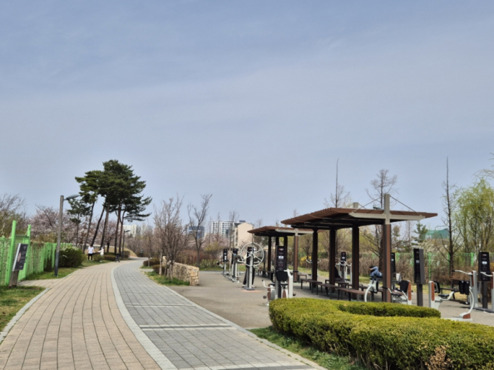 공원 놀이터에는 아이들이 뛰어놀고, 운동하는 어르신들이 보인다