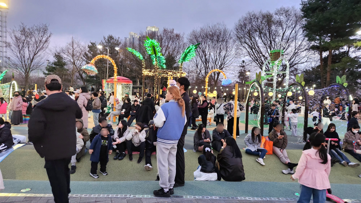 가족 단위, 또는 친구, 연인과 함께 온 관람객들이 놀이도 하며 공연을 즐기고 있다.