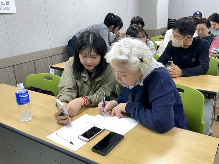 어르신과 대학생들이 1:1 짝꿍 스마트폰 사용법을 가르치고 배우는 다정한 모습