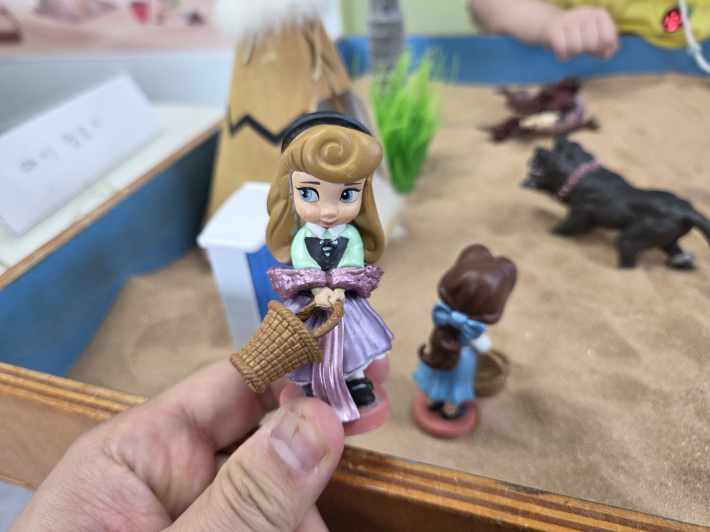 보호자가 창조자가 되어 모래상자를 구성하는 장면