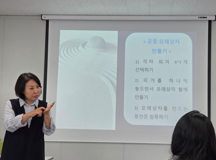 모래놀이 진행 방법을 설명하는 강사의 모습