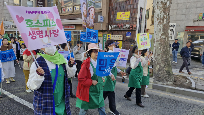 수원 중심 거리를 행진하는 초록 앞치마 자원봉사자들