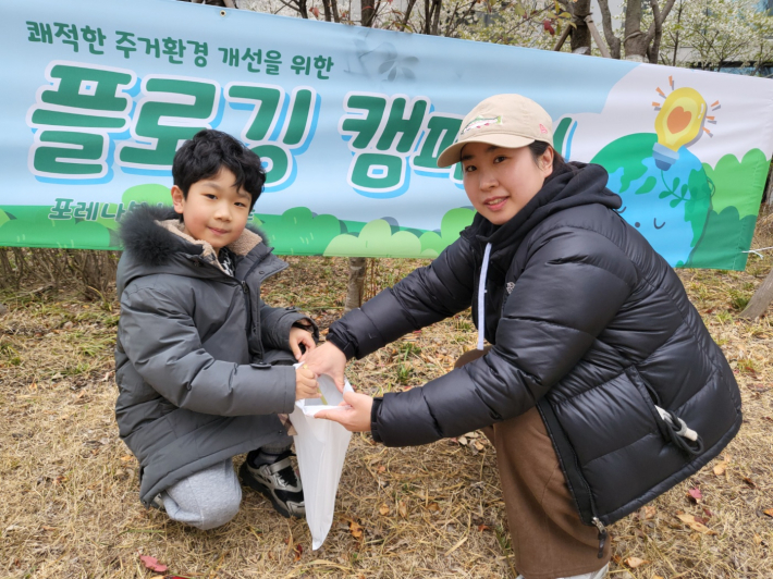 엄마와 함께 손을 맞추며 쓰레기를 담는 이우주 어린이. 작은 손길이 만드는 큰 변화의 시작이다.