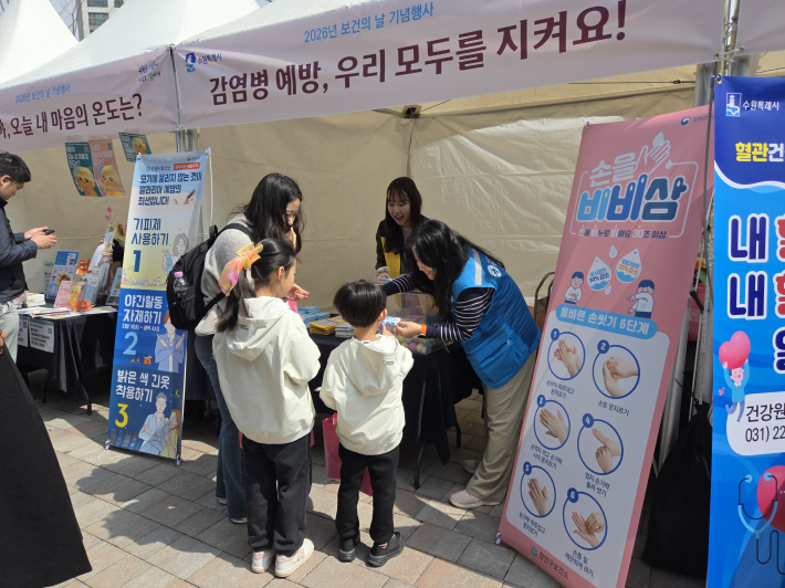 두 자녀가 엄마와 함께 손씻기 방법에 대해 듣고 있다. 