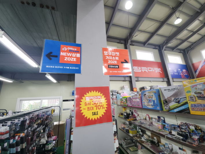 'NEW상품존'과 '가치소비존' 안내 표지판과 함께 다양한 리퍼브 상품이 진열된 땡큐마켓 매장 내부 모습