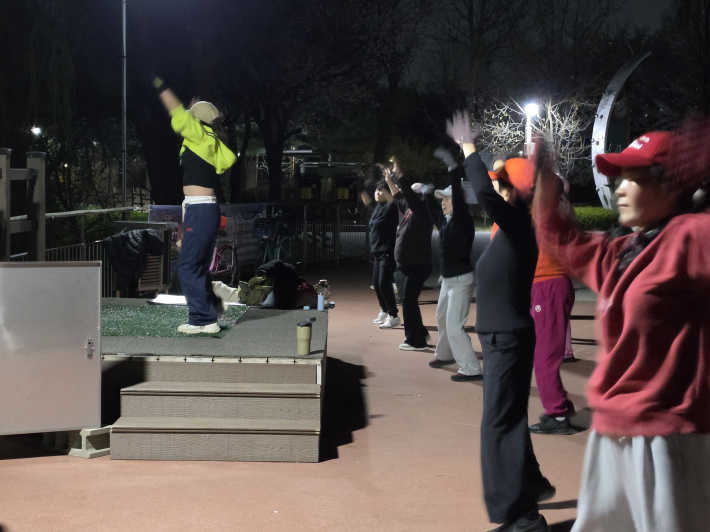 강사의 동작을 따라 운동에 집중하는 참가자들