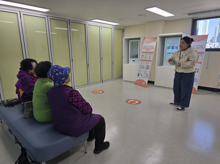 스마트기기인 버츄얼메이터를 통해 어르신들에서 사용방법을 담당자가 설명하는모습