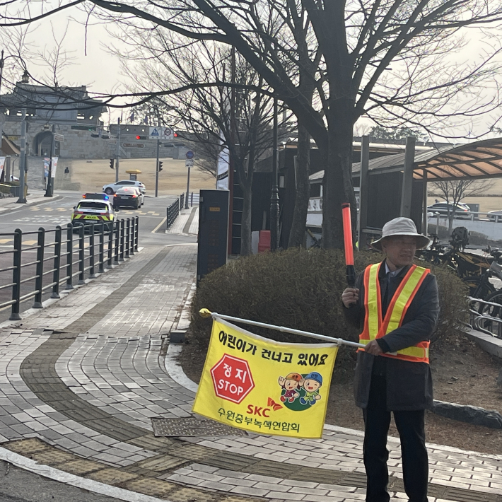 행궁동 경기행복마을관리소 지킴이가 교통안전지도를 하고 있다.