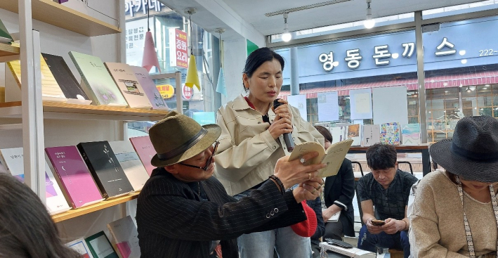 한 독자가 용 시인의 시를 낭독하고 있다.