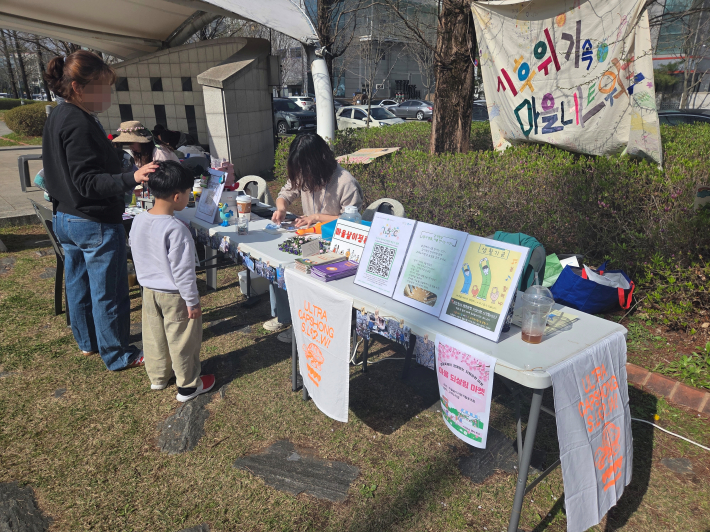 마을 되살림 마켓 체험 프로그램에 참여하며 즐거운 시간을 보내는 가족의 모습