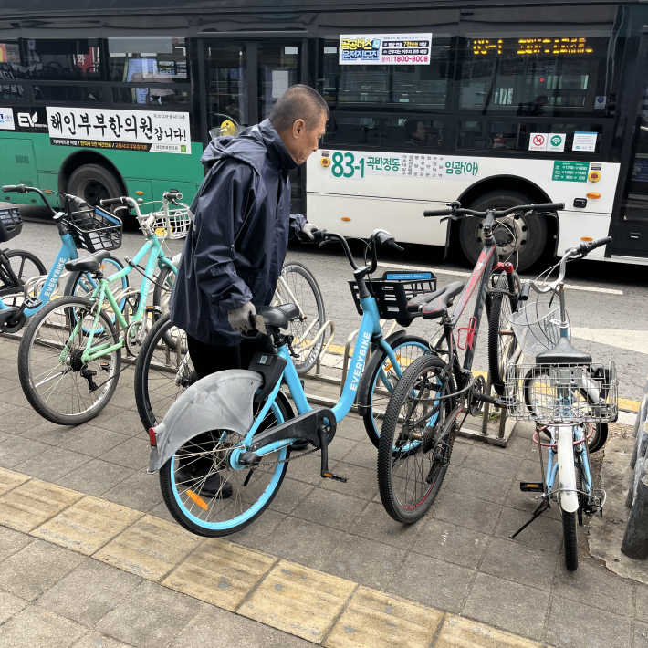 행궁동 경기행복마을관리소 지킴이가 보행에 방해가 되는 자전거를 안전한 장소로 옮기고 있다