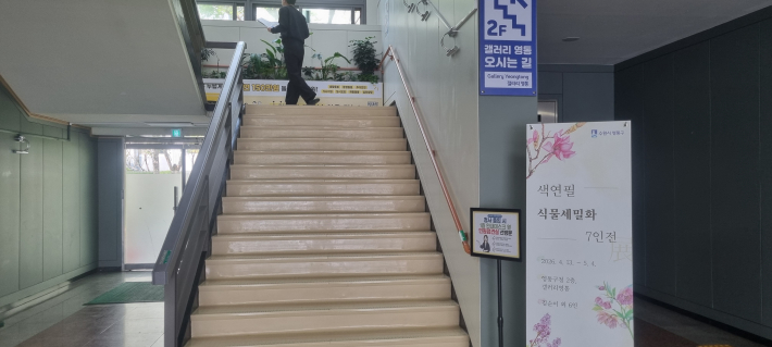 2층 갤러리 영통에서의 7인전 전시를 안내하고 있다. 