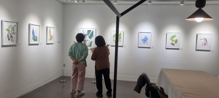 전시된 작품을 감상하는 두 명의 관객들