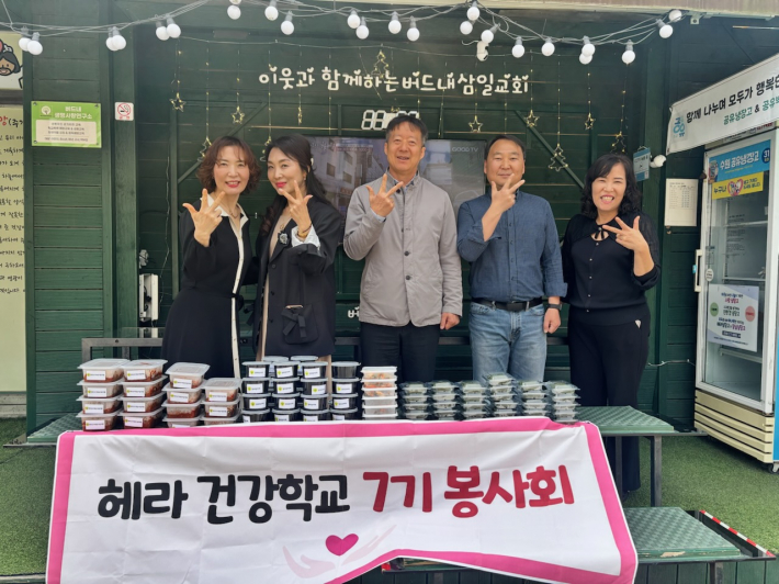 헤라 건강학교 7기 봉사회와 새마을부녀회가 세류3동 공유냉장고에 반찬을 기부하고 기념촬영을 하고 있다.