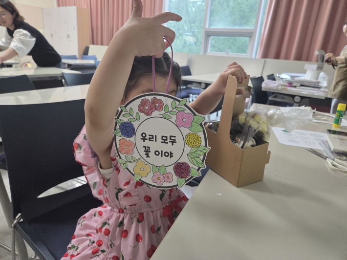 색칠로 완성한 리스를 들고 환하게 웃는 모습