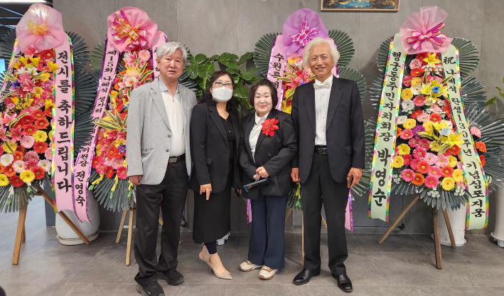 이순옥 화가가(오른쪽 2번째)팔달문화센터 예당마루 입구에 설치된 화환 앞에서 내빈을 맞이하고 있다.