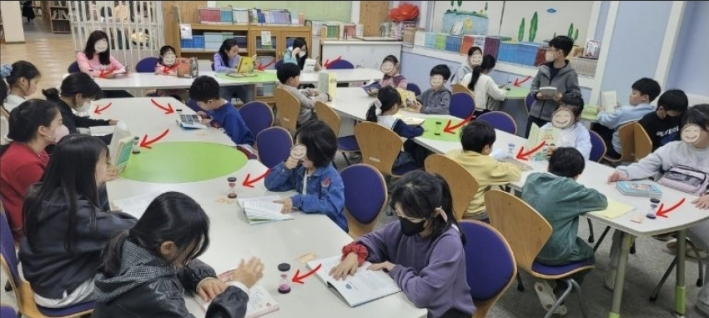 아이들이 청명초 글벗도서관에서 모래시계를 놓고 책을 읽는 장면