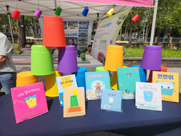 형형색색 컵과 그림책을 활용해 놀이처럼 책을 즐길 수 있도록 구성된 체험 부스 모습