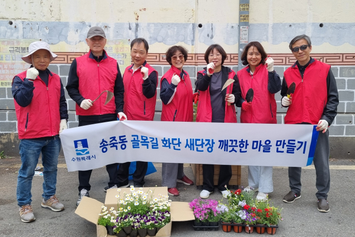 수원시 송죽동 주민자치회 위원들이 골목길 화단을 정비한 뒤 기념촬영을 하고 있다.