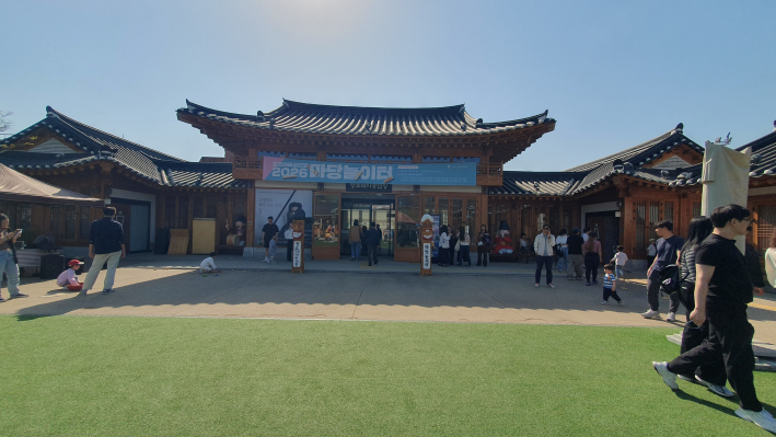 '2026 마당놀이터' 현수막이 걸린 정조테마공연장 외관. 맑은 봄 날씨 속 관람객들이 공연장을 찾고 있다.