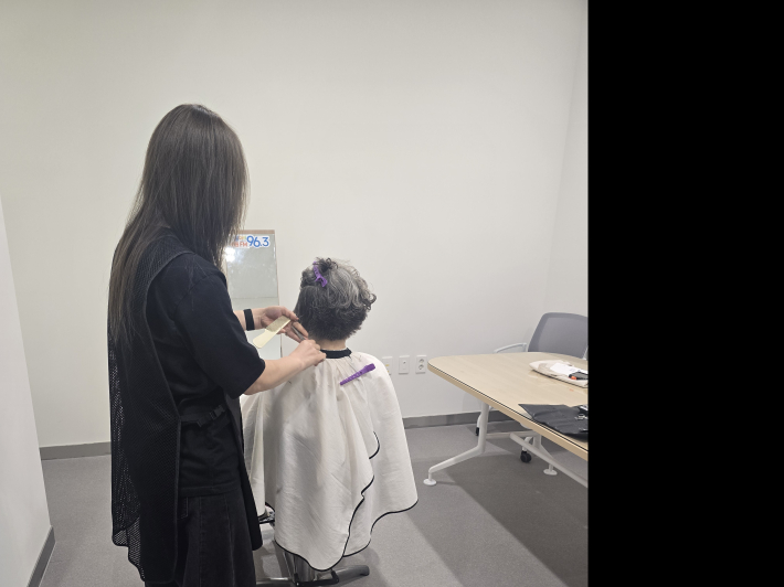 보민헤어 김보민 원장이 어르신들이 머리를 다듬어 주고 있다.