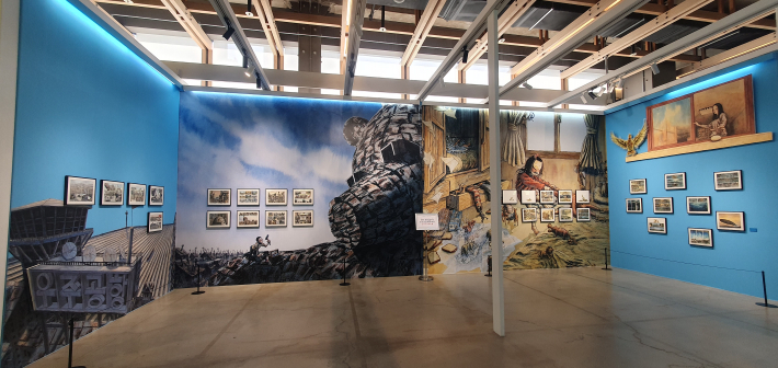 이기훈 작가 공간 전경. 양철곰과 알의 대형 벽화와 원화가 푸른 전시장 안에 배치돼 묵직한 분위기를 만든다.