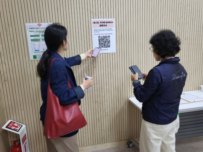 수업 종료 후, 모녀가 나란히 앉아 QR코드를 통해 강의 평가 설문에 참여하고 있다.