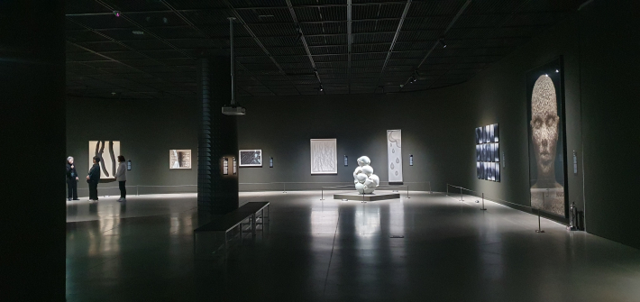 이수경의 '번역된 도자기_2019 TVW 5'와 김두진의 '대지-엄마의 땅' 등이 보이는 전시장 전경. 도슨트 해설 장면이 함께 담겨 기사 현장감을 살리기 좋다.