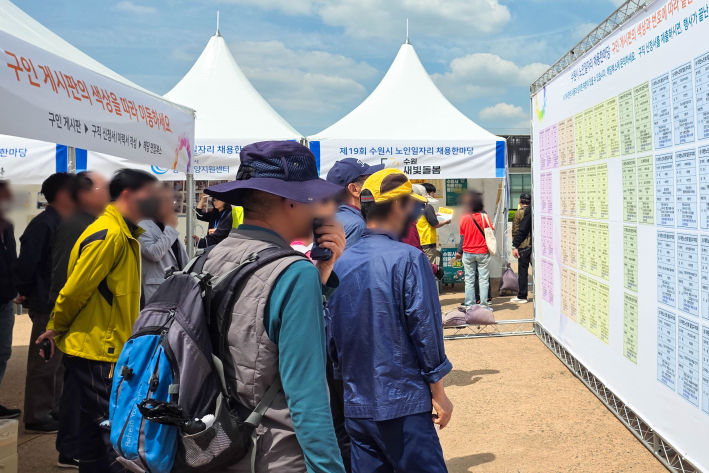 사진)'노인일자리 채용한마당'에 참가한 어르신들이 게시판을 살펴보고 있다.    