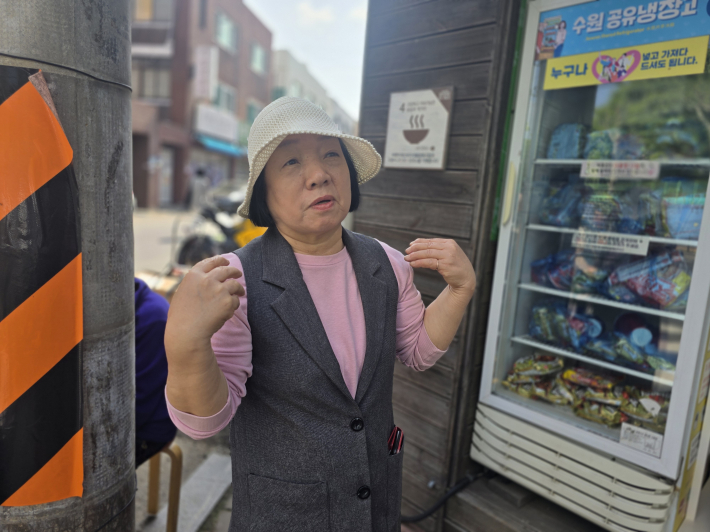 공유냉장고 앞에서 나눔 활동에 대해 이야기하는 매탄동 통장.