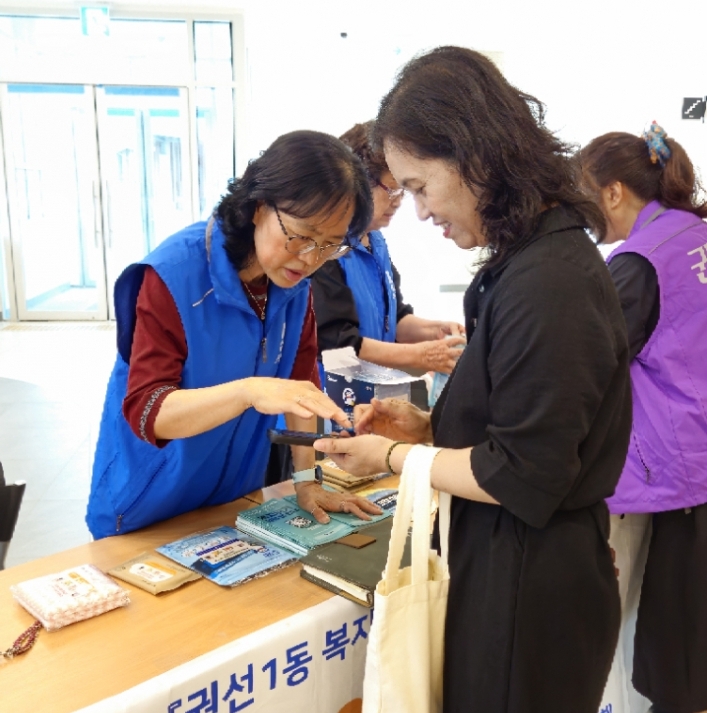 협의체 위원이 주민들에게 복지위기알림앱을 홍보하고 설치를 도와주고 있다. 