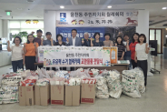 율천동 주민자치회 위원들이 우유팩과 교환물품 앞에서 기념사진을 찍고 있다.