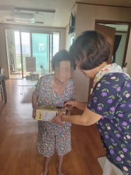 지사협위원이 어르신에게 건강음료를 전달하는 모습입니다.
