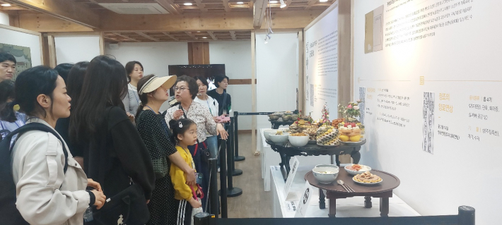 상설전시장에서 혜경궁 홍씨의 봉수당 진찬연 해설을 듣고 있다.