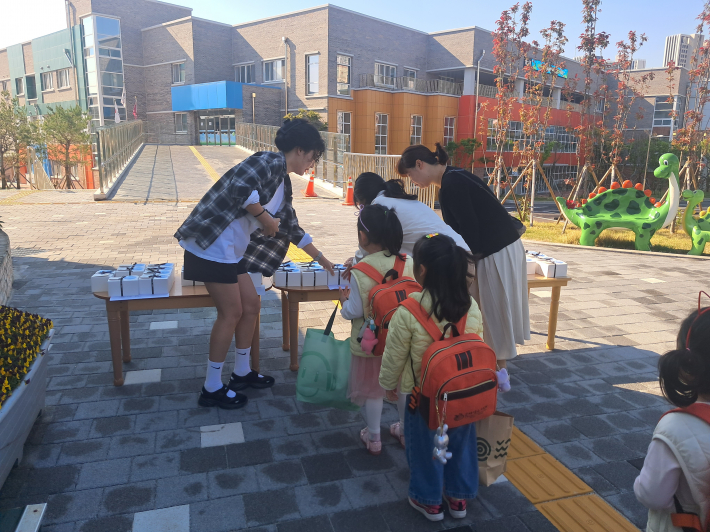 학부모회에서 등원하는 유아들에게 선물을 나누어주고 있는 모습