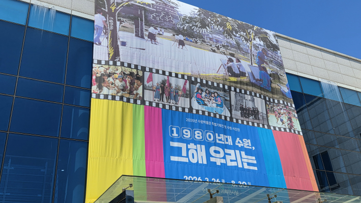 2026년03월 26부터 8월 30일까지 진행되는 기획전시 '1980년대 수원, 그해 우리는' 대형 현수막이 수원박물관 외관에 부착되어 있다.