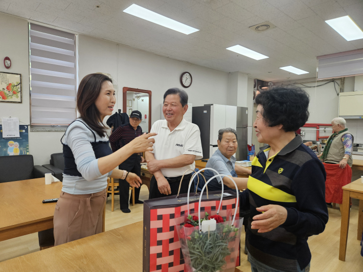 매탄4동장은 경로당 어르신들께 카네이션과 선물세트를 전달하고 있다.
