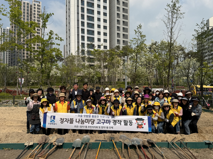 정자1동 주민자치회와 통장협의회, 주민들이 정자뜰에서 단체사진을 찍고 있다.