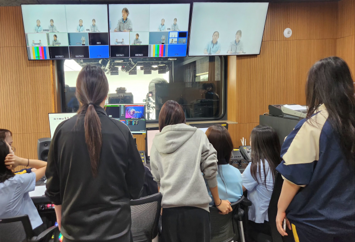 학생들이 조정실에서 카메라 전환과 자막·음향 장비를 직접 조작하며 방송 제작 과정을 배우고 있다.