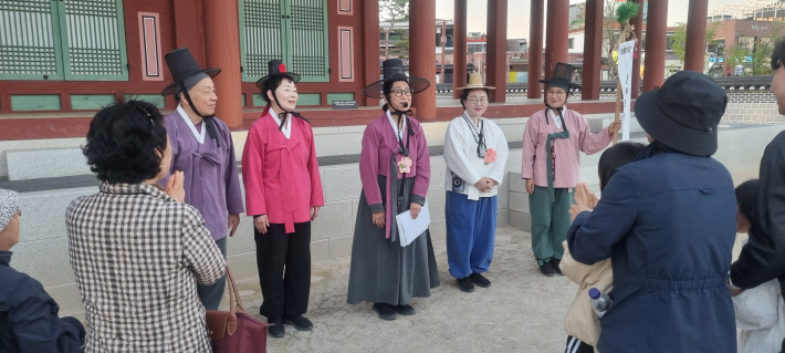 우화관에서 주민 배우와 고궁 산책을 마무리하며 인사하고 있다. 