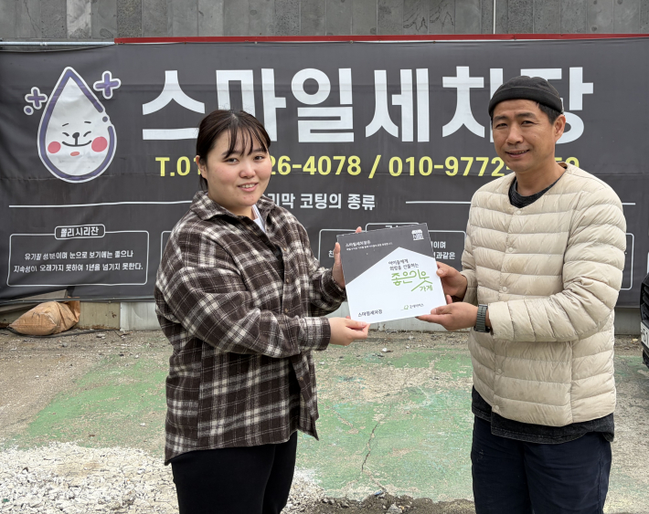 스마일세차장에 좋은이웃가게 현판을 전달하는 모습