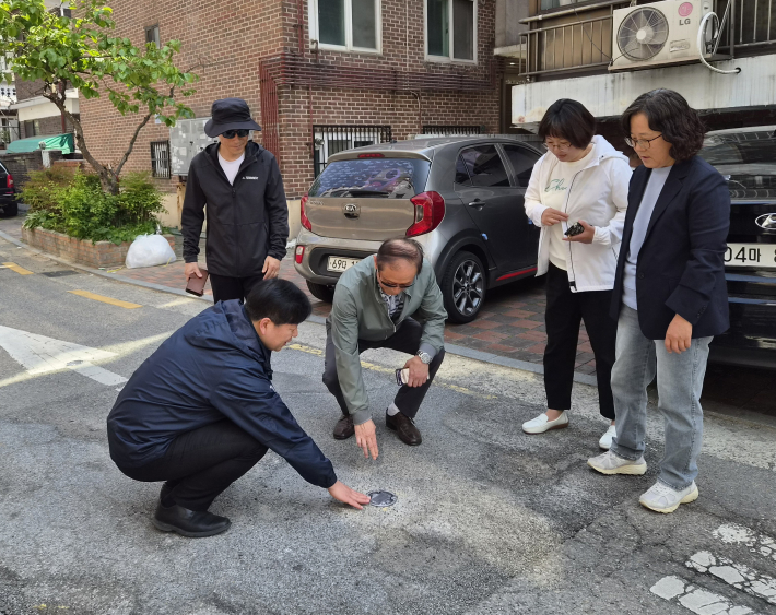 송죽동 주민자치회가 도로표지병 준공 현장을 확인하고 있다.