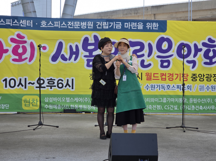 최광자 전임 자원봉사회장(권사)이 하나호스피스 소개를 하고 김명자 사회자와 찬양을 부르고 있다.