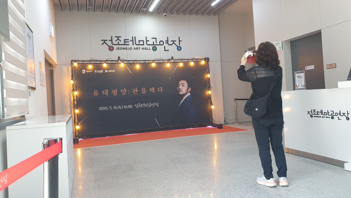 공연 시작 전 로비에 마련된 《유태평양: 판을 깨다》 포토월을 촬영하는 관객