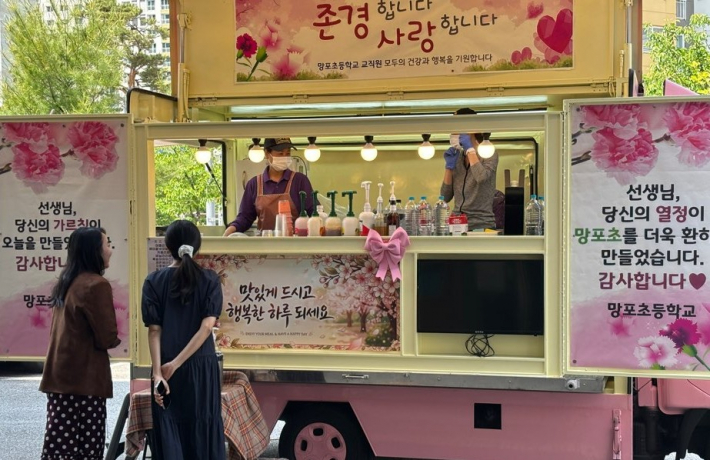 감사 메시지를 읽으며 커피를 나누는 선생님들 